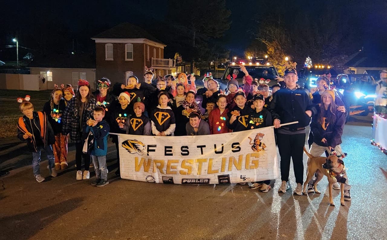 FYWC wrestlers and families gathered behind a Festus Wrestling banner